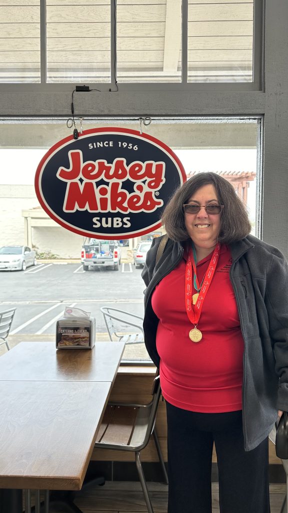 Jersey Mikes - Woman in front of Jersey Mike's Sign