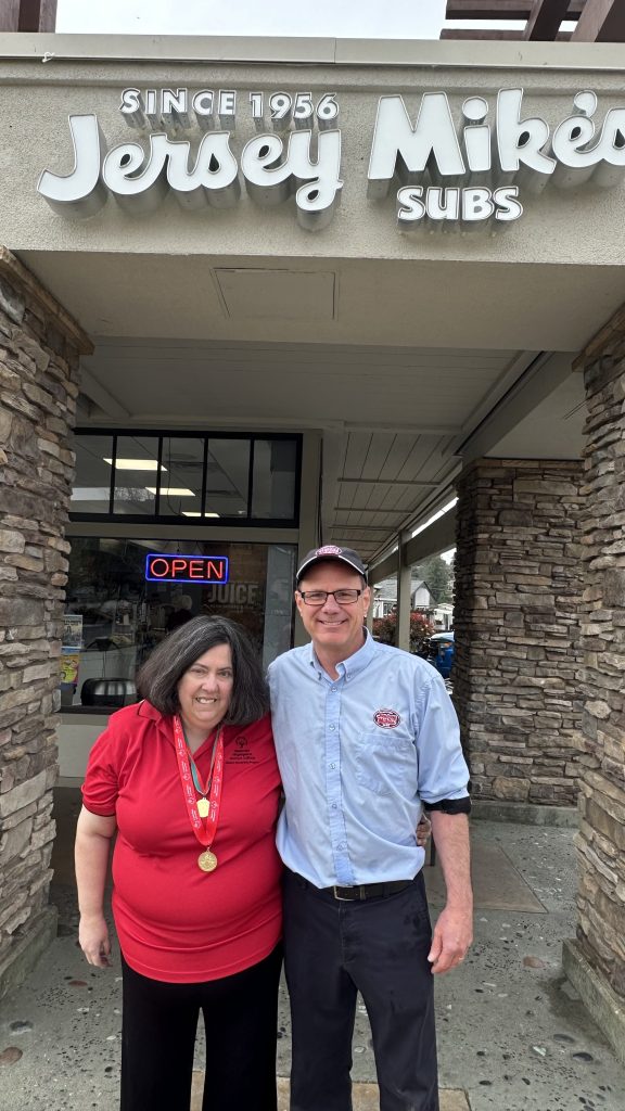 Jersey Mikes - Woman and man in front of Jersey Mike's storefront