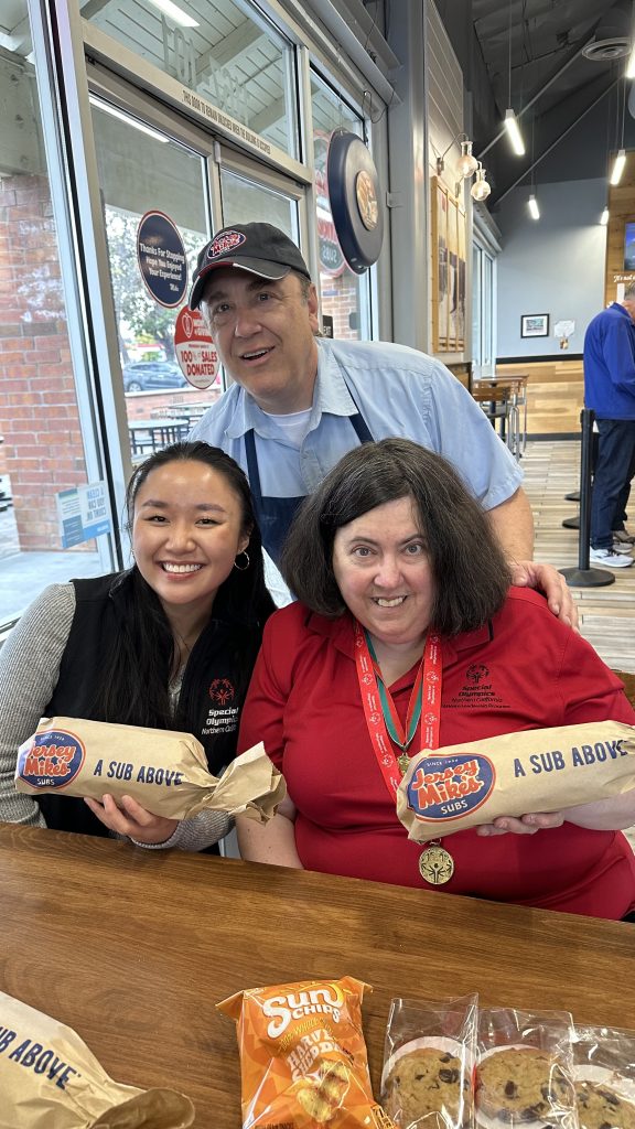 Jersey Mikes - Two women and employee holding a sub