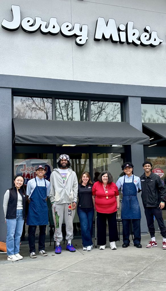 Jersey Mikes - Athletes, Santa Clara University players, and employees under Jersey Mike's sign