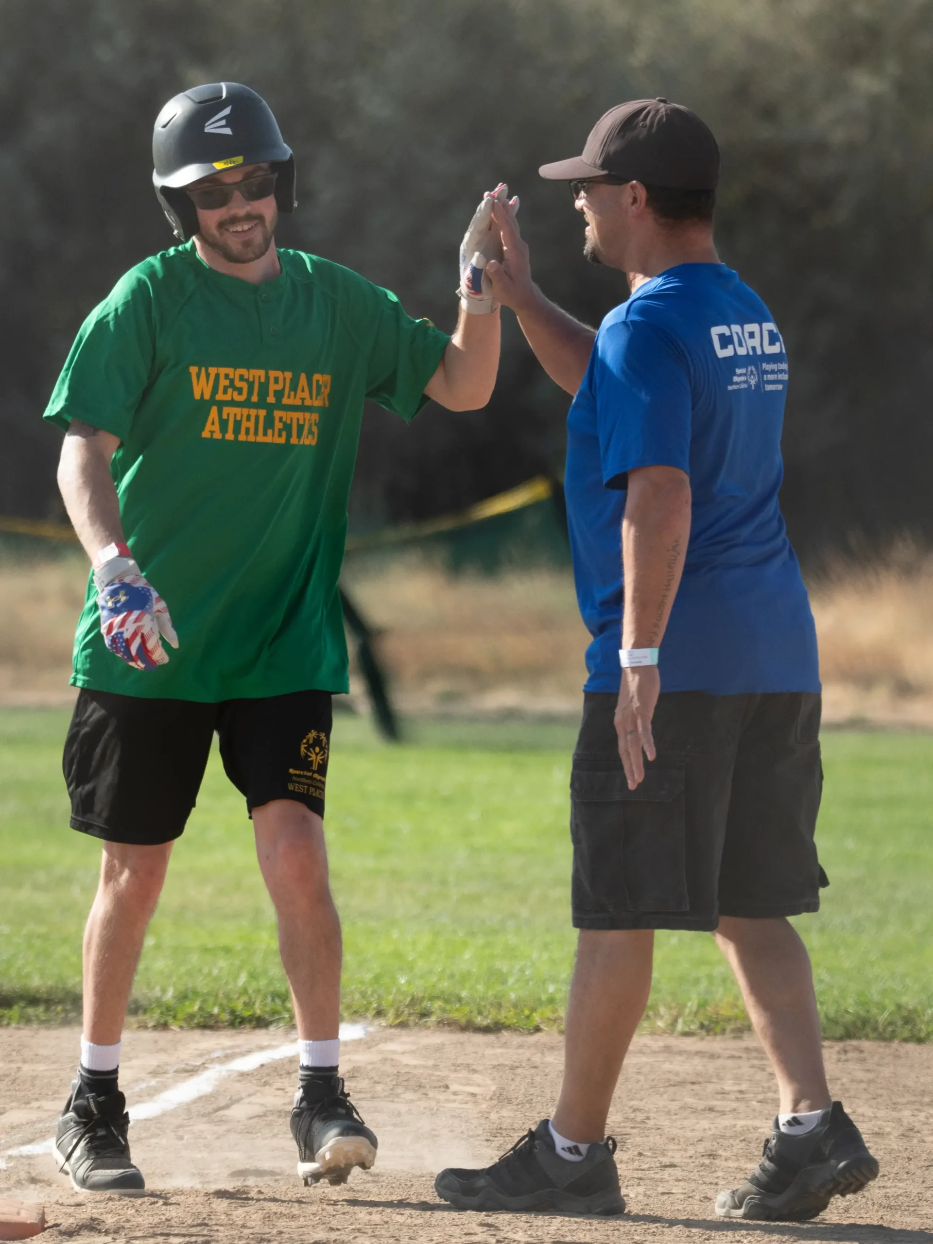 Volunteer Coach with softball player high-fiving