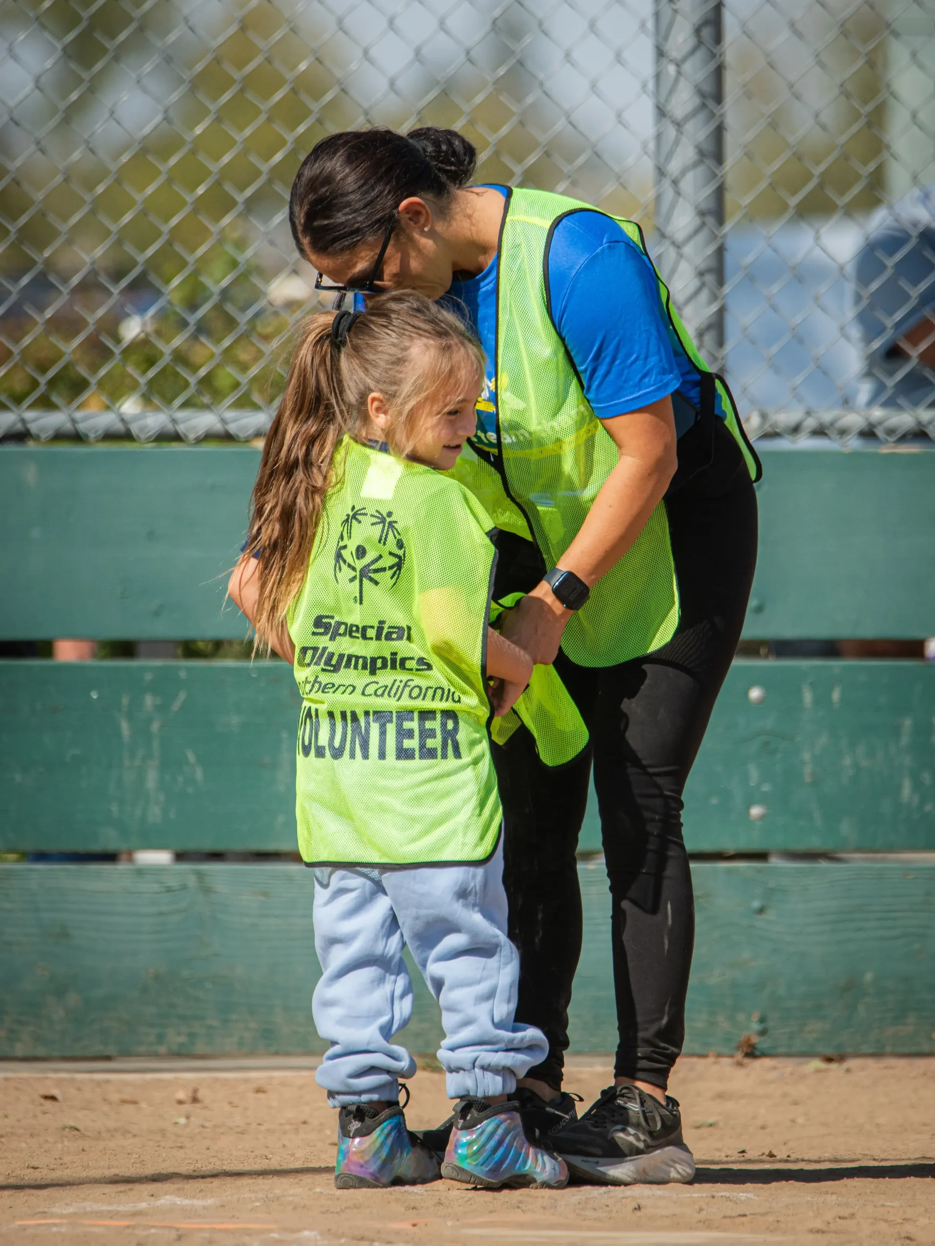 Mother and daughter putting on volunteer vests